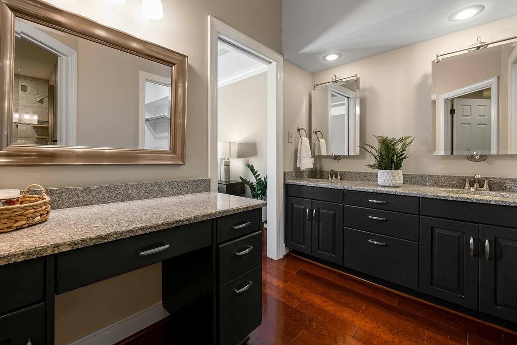 Elegant bathroom with dark wood cabinets, granite countertops, and modern fixtures.