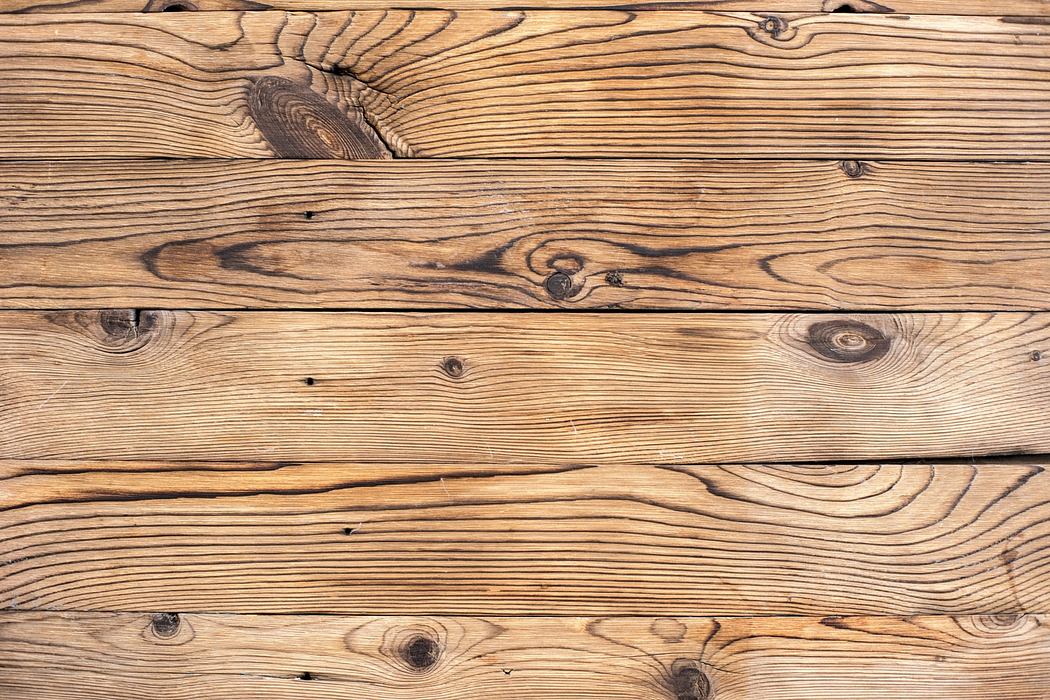Rustic wooden planks with natural grains and knots, suitable for interior or exterior design.