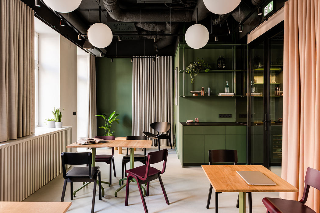 A modern, stylish office interior featuring bold green accents, minimalist furnishings, and pendant lighting.