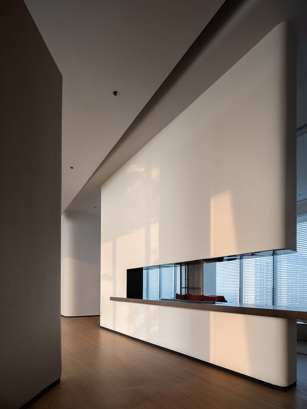 A minimalist interior design with a sleek white reception desk and clean lines.