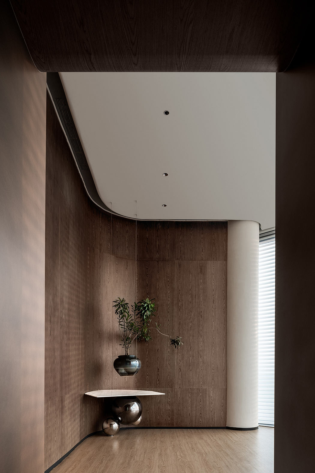 Minimalist interior design featuring dark wooden paneling, recessed lighting, and a decorative vase.