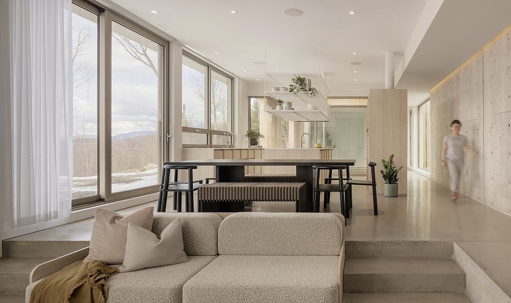 Spacious, minimalist living room with large windows, modern furniture, and nature-inspired decor.