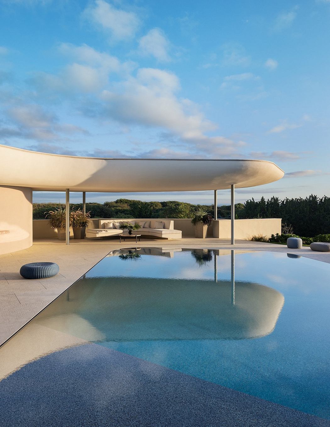 Sleek, modern pavilion with curved roof and swimming pool, surrounded by lush vegetation.