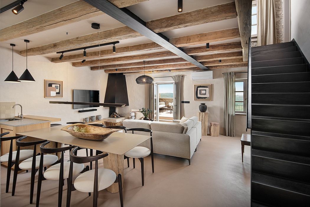Open-concept living area with exposed wooden beams, modern furniture, and a large window.