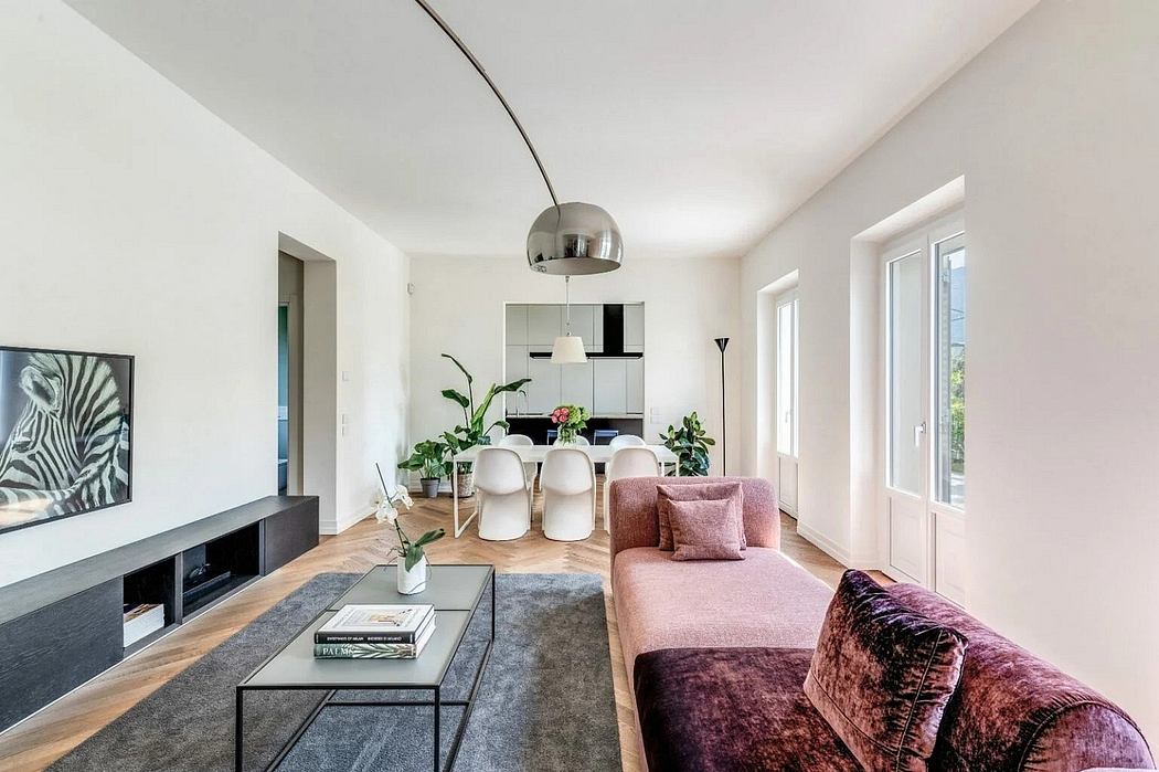 Spacious, modern living room with minimalist furnishings, vibrant pink sofa, and large windows.