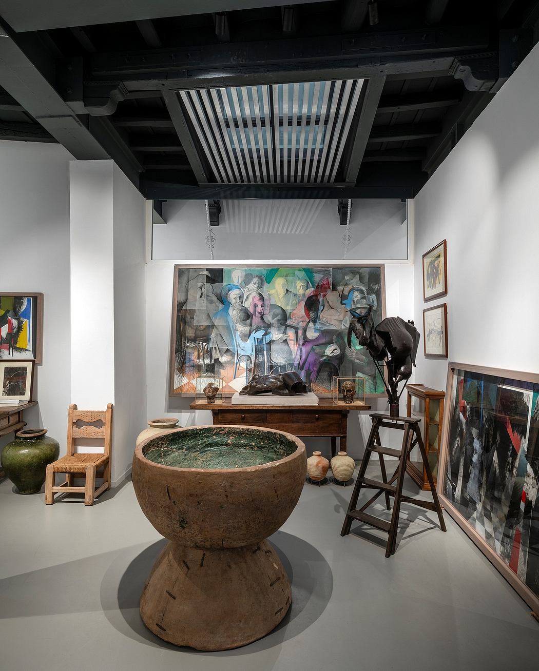 Well-curated art gallery with eclectic mix of sculptures, paintings, and architectural elements.