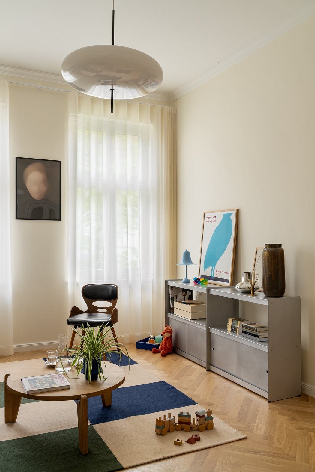 A cozy living room with a modern lighting fixture, hardwood floors, and a stylish console table.