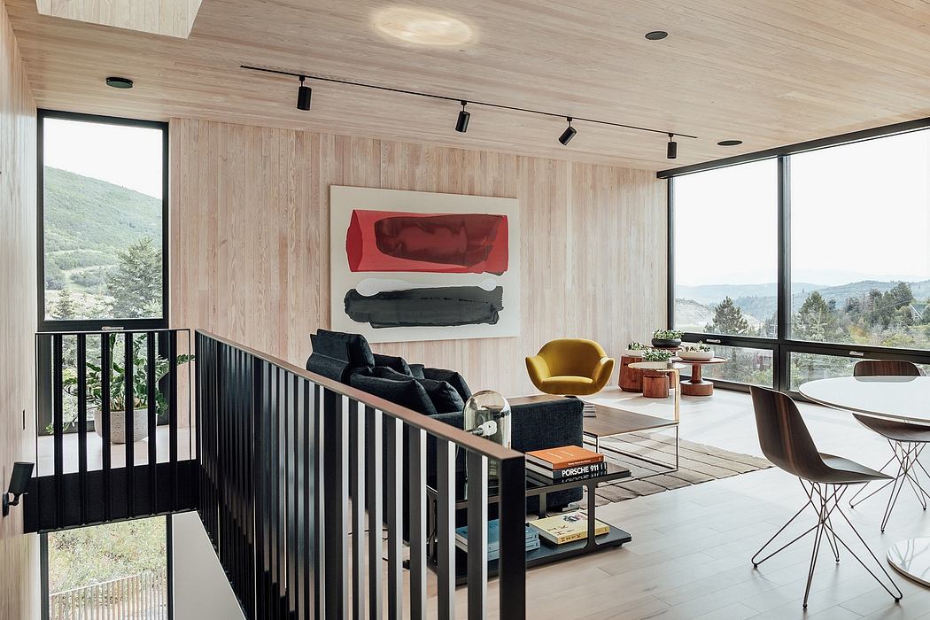 Modern, open-concept living room with wood paneling, bold artwork, and panoramic mountain views.
