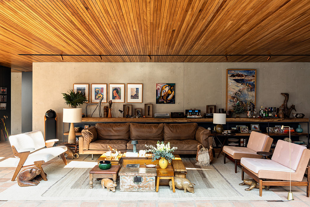 Warm, rustic living room with wooden ceiling, concrete walls, and eclectic furnishings.