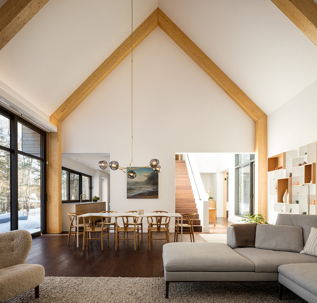 Spacious open-plan interior with high vaulted ceilings, wooden beams, and modern furnishings.