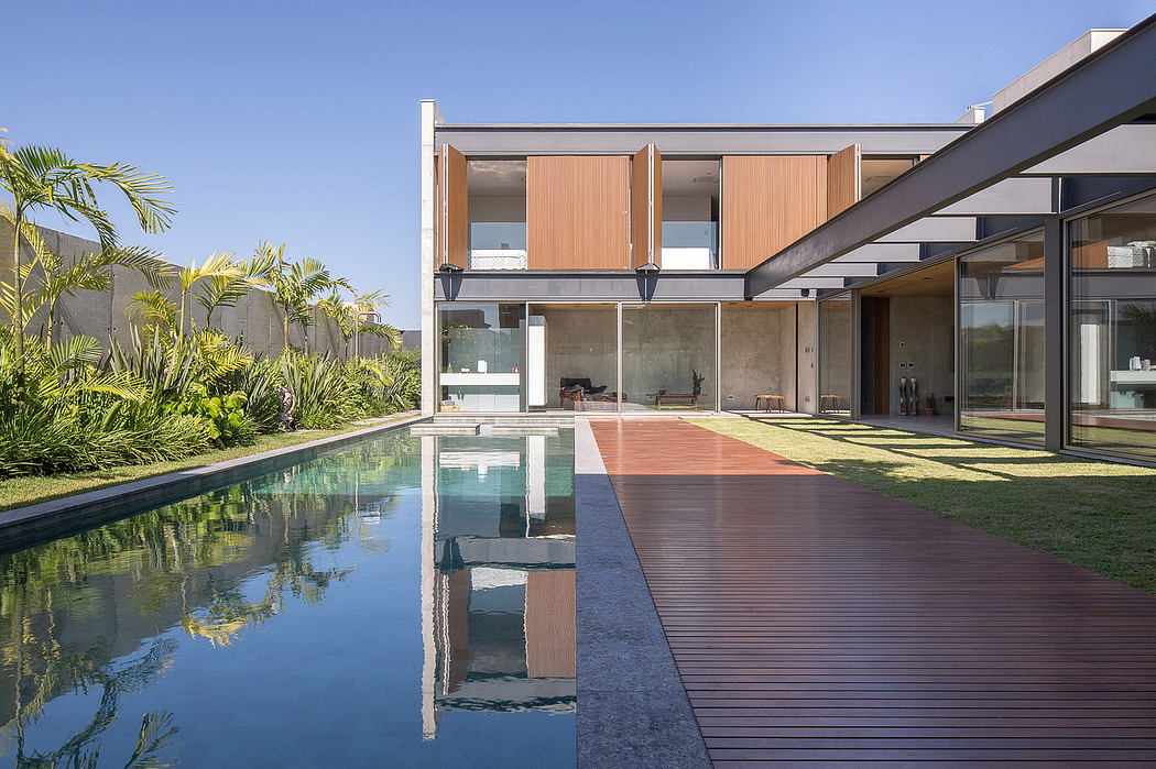 A modern house with a pool, wooden decking, and concrete and glass exterior elements.