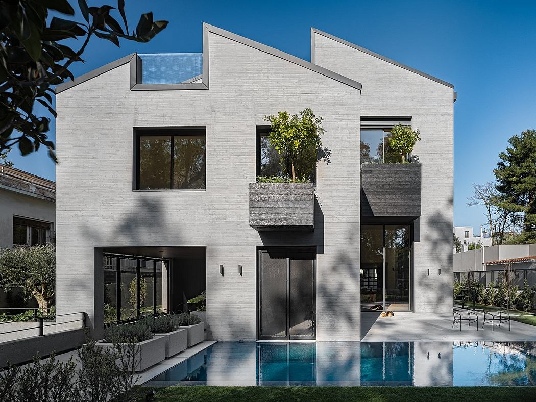Sleek, modern home with geometric shapes, concrete exterior, and a reflection pool.