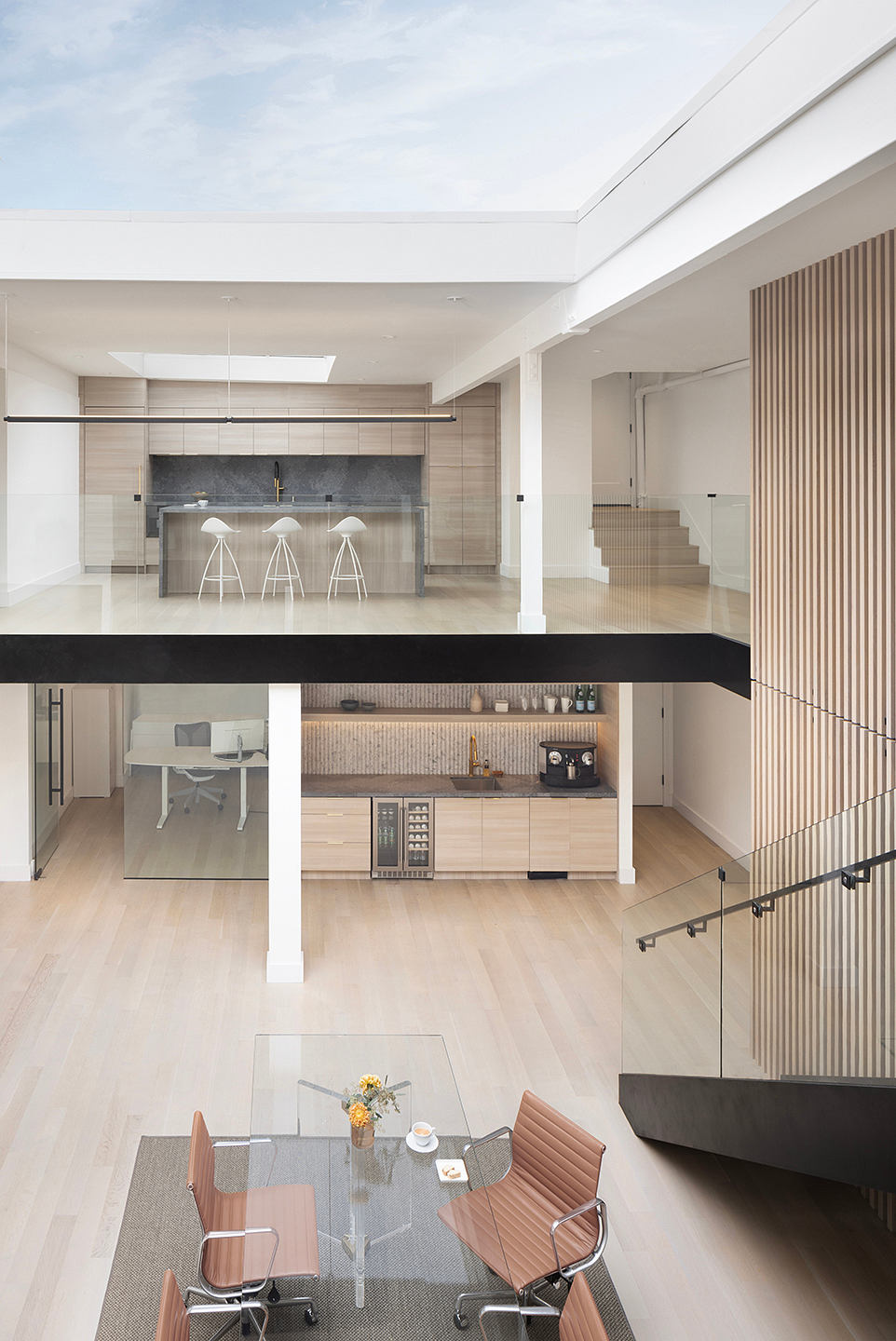 This open-concept home features a modern kitchen, dining area, and workspace with neutral tones.