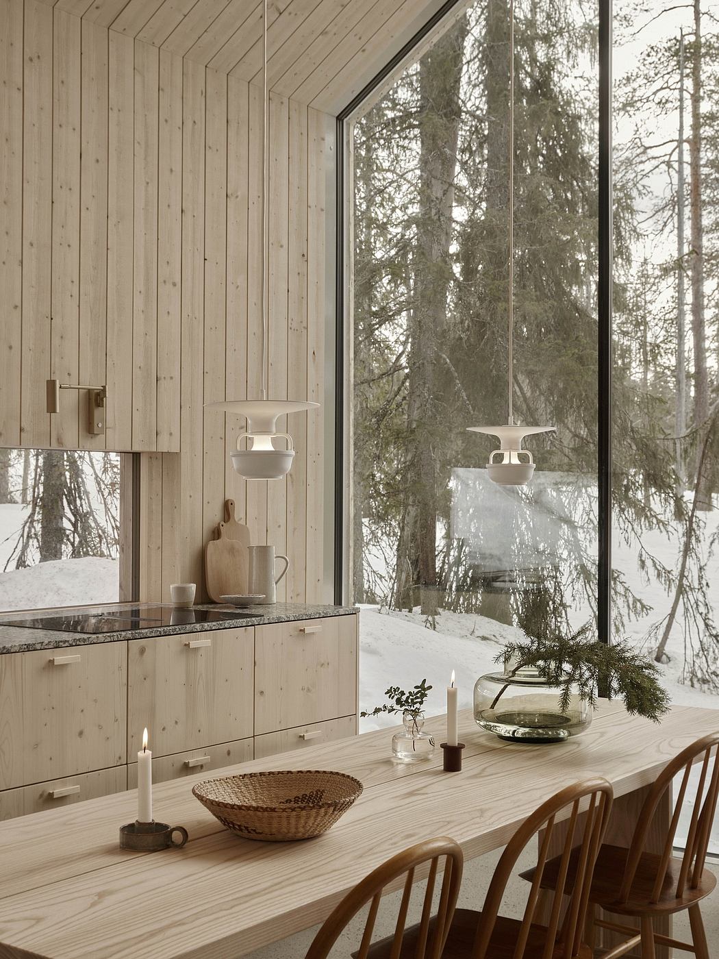 Cozy winter cabin interior with wooden walls, large windows, and a rustic dining area.