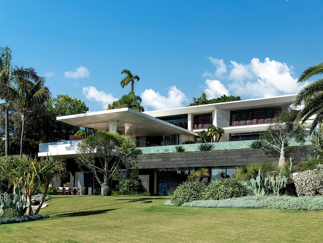 Striking modern architecture with lush tropical landscaping surrounding a tiered building.