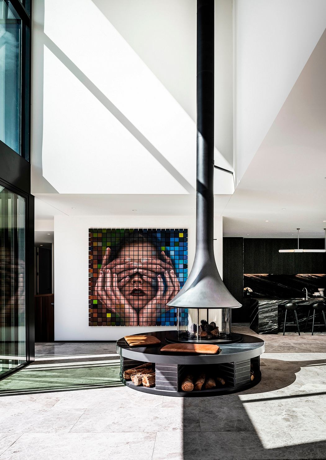 Dramatic entryway with striking geometric light fixture, mosaic artwork, and sleek circular fireplace.