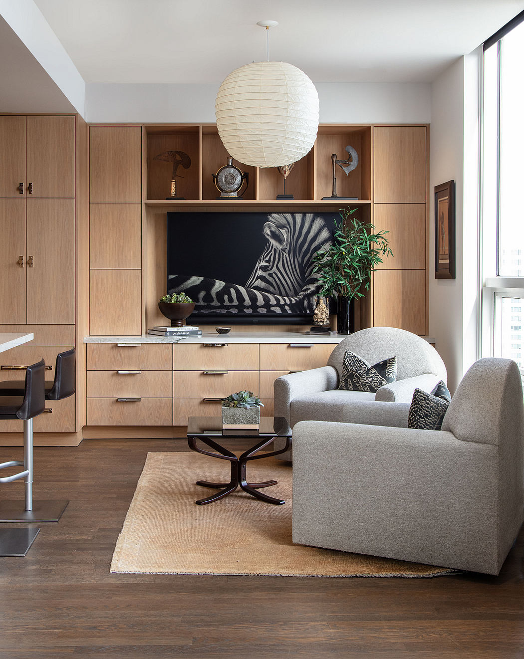 A modern living room with wooden cabinetry, stylish furnishings, and a striking zebra-print artwork.