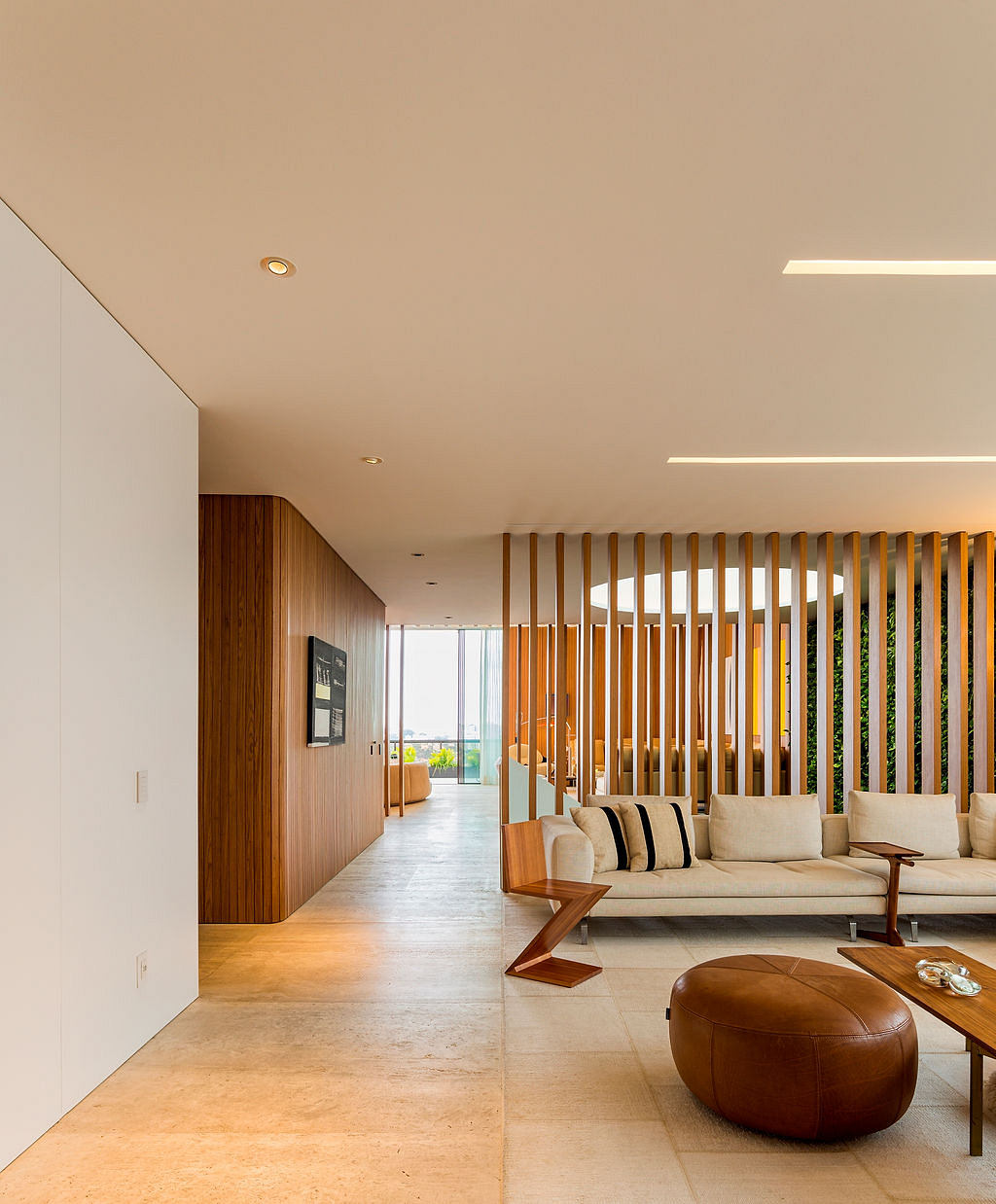 Spacious modern living room with wood paneling, sleek furniture, and abundant natural light.