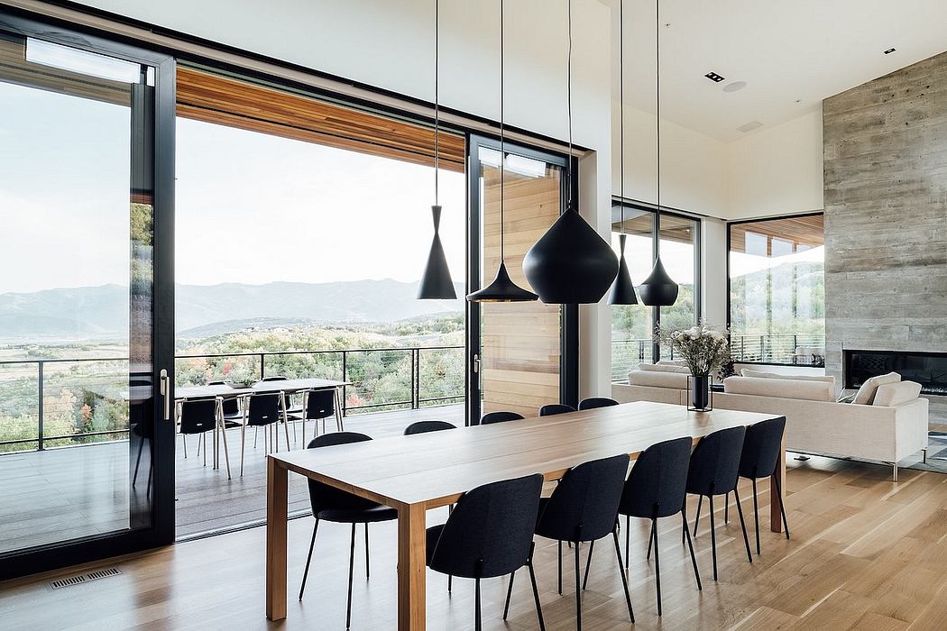 Spacious modern dining room with large windows, wooden accents, and sleek black pendant lights.