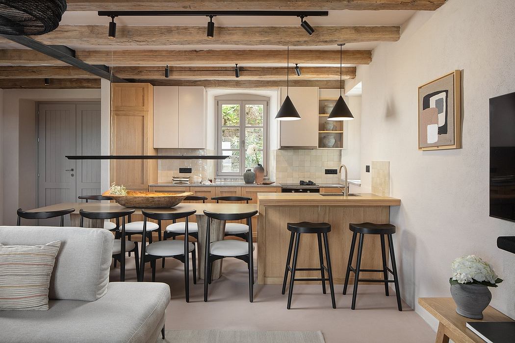 A cozy kitchen with rustic wood beams, modern lighting, and minimalist furnishings.
