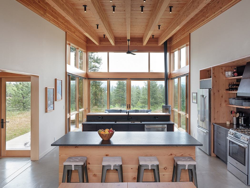 A modern, open-concept kitchen with wood-beamed ceilings, large windows, and a central island.