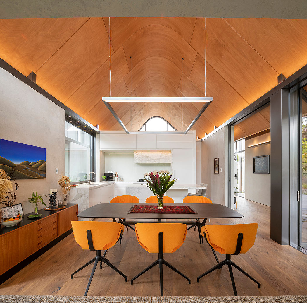 Bright, open-concept living space with wooden ceiling, sleek furnishings, and vibrant accents.