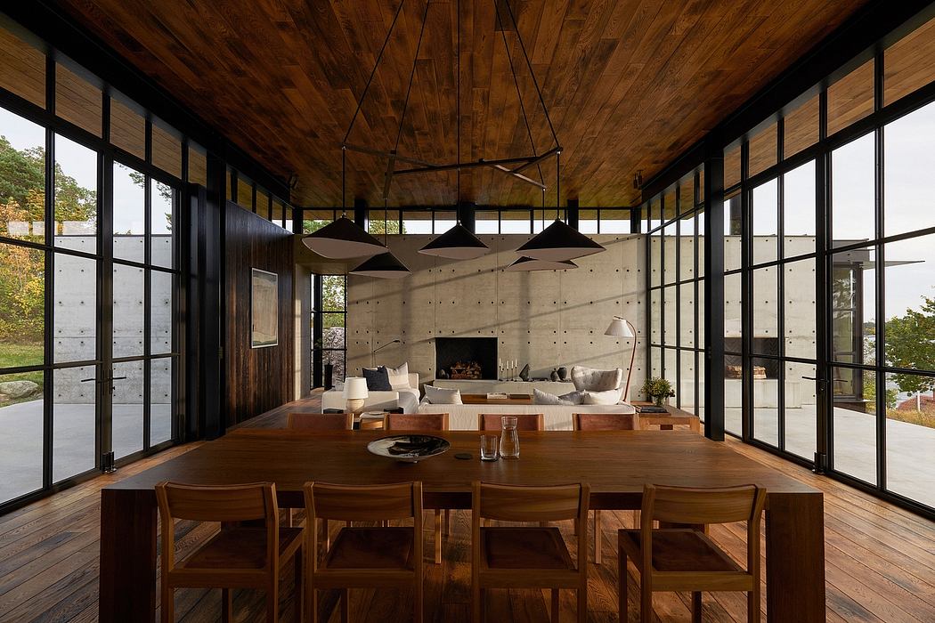 Rustic wooden beams, concrete walls, and floor-to-ceiling windows create a modern, cozy space.