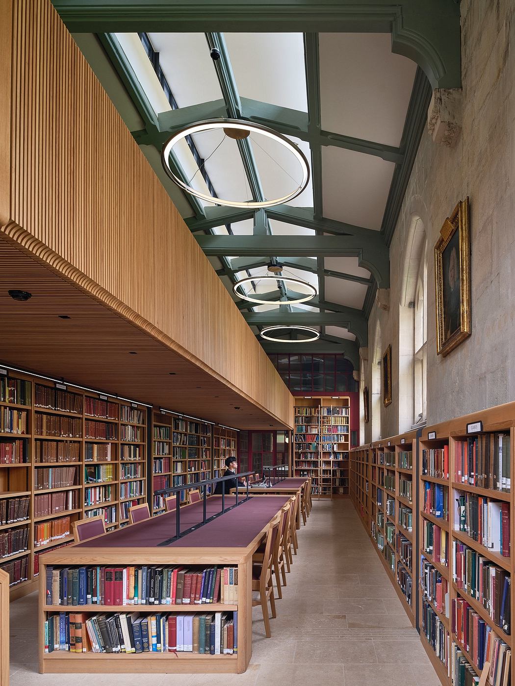 A grand, wood-paneled library with a vaulted glass ceiling and rows of bookshelves.