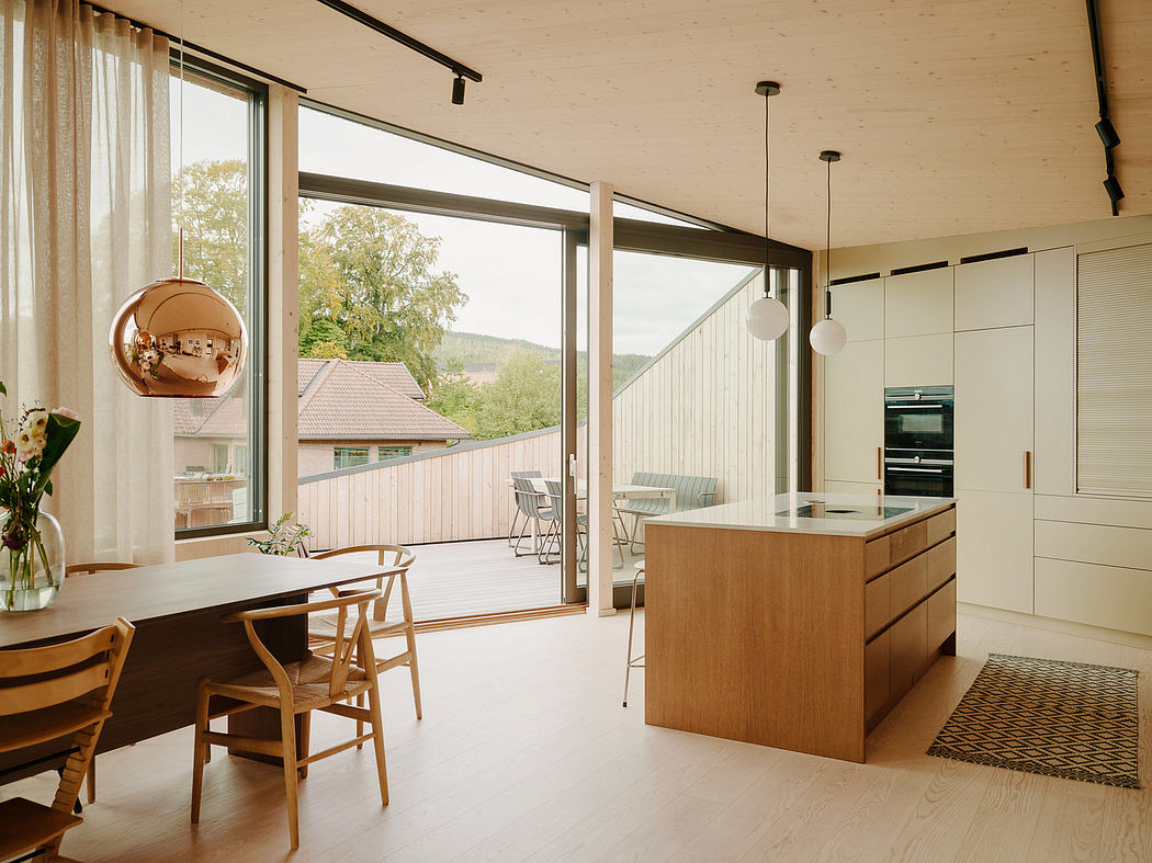 Bright, open-plan kitchen and living area with large windows offering scenic views.