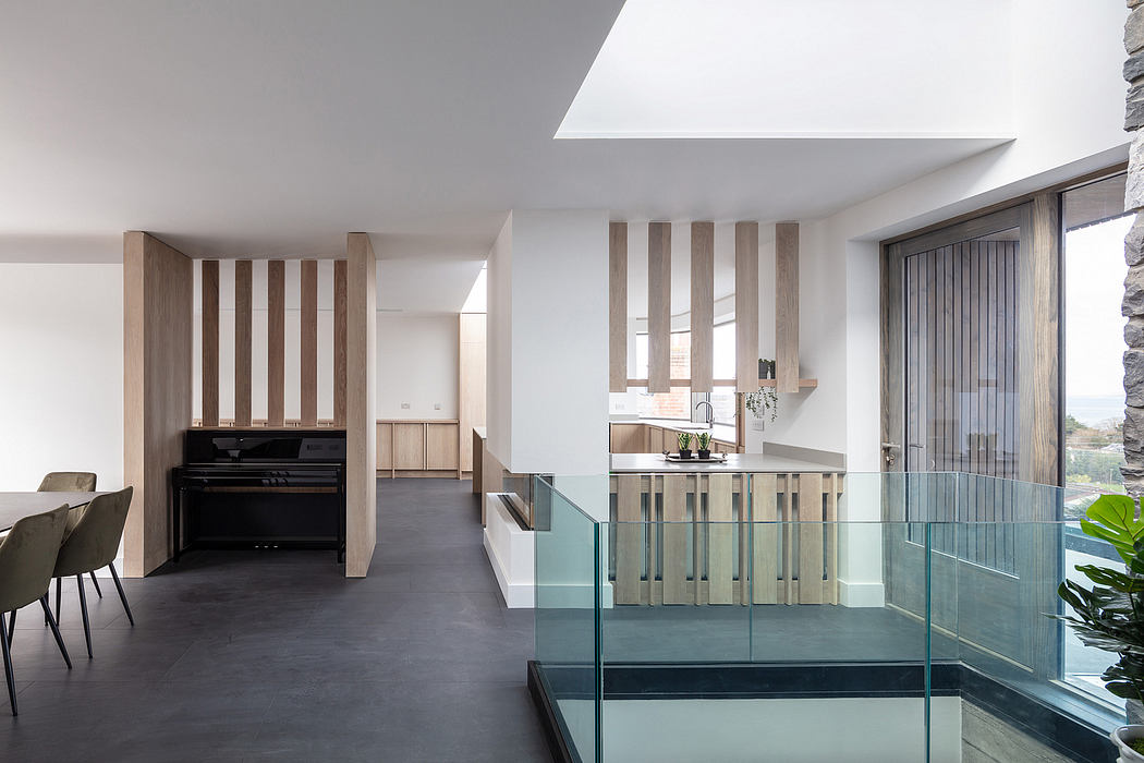 Modern, minimalist kitchen with wooden accents, glass partitions, and sleek appliances.