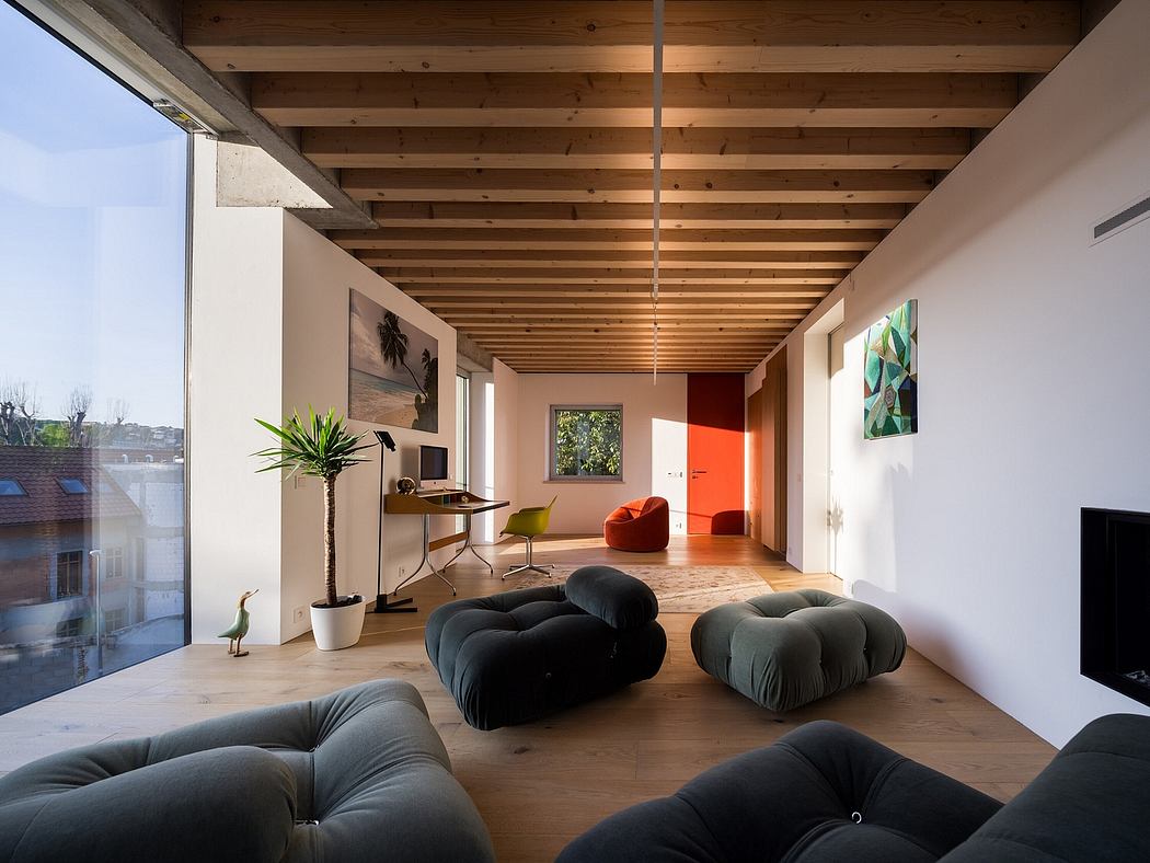 Bright, open-concept living space with exposed wooden beams, plush seating, and vibrant artwork.