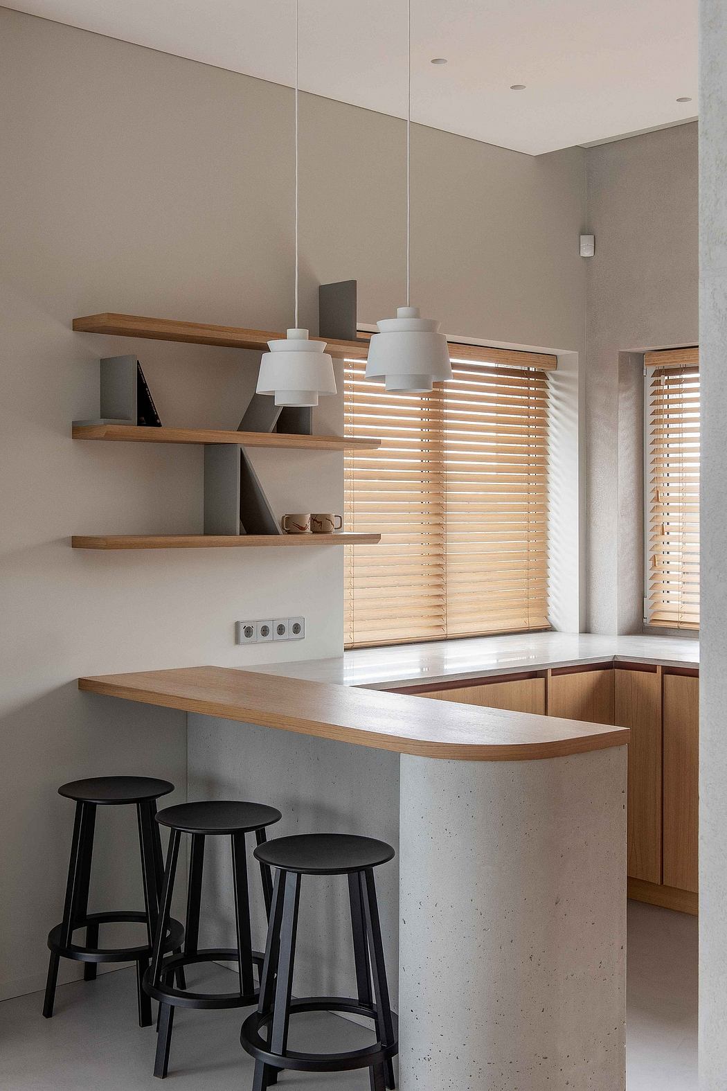 Minimalist kitchen design featuring wooden shelves, blinds, and stools against a neutral-toned wall.