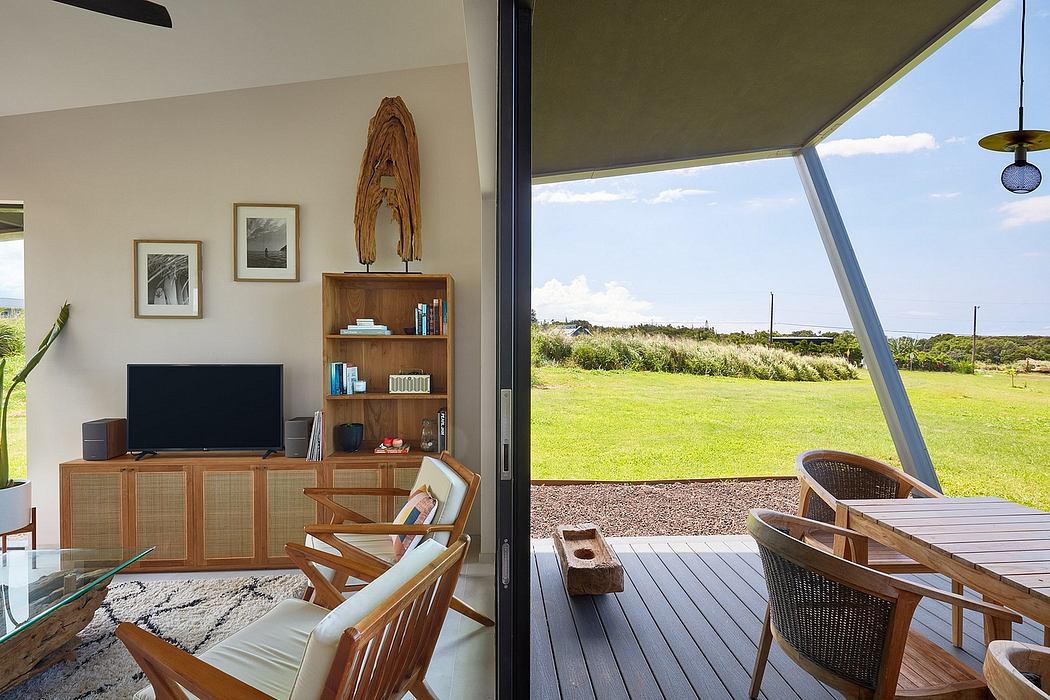 A cozy living room with wooden furniture, shelves, and a picturesque outdoor view.