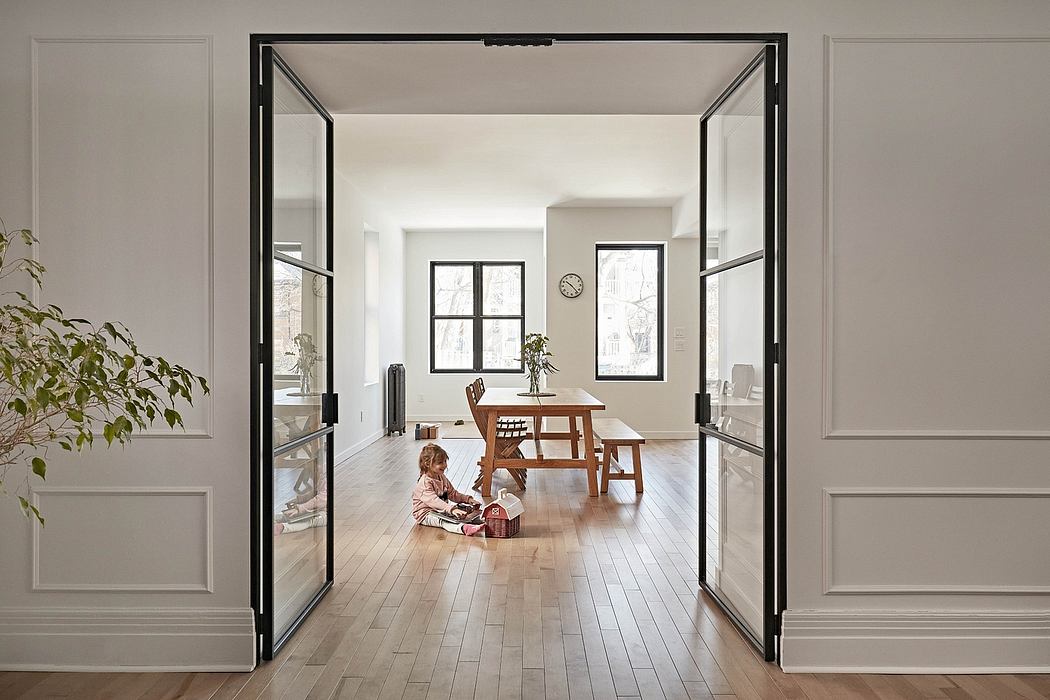 A spacious, modern living room with large windows, wooden floors, and a minimalist design.