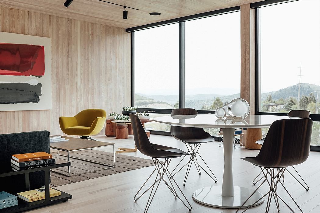 Minimalist dining area with wooden walls, large windows, and unique furniture pieces.