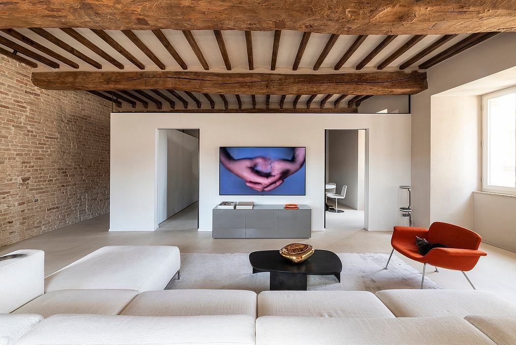 Exposed wooden ceiling beams, neutral-toned modern furniture, and large wall-mounted TV.
