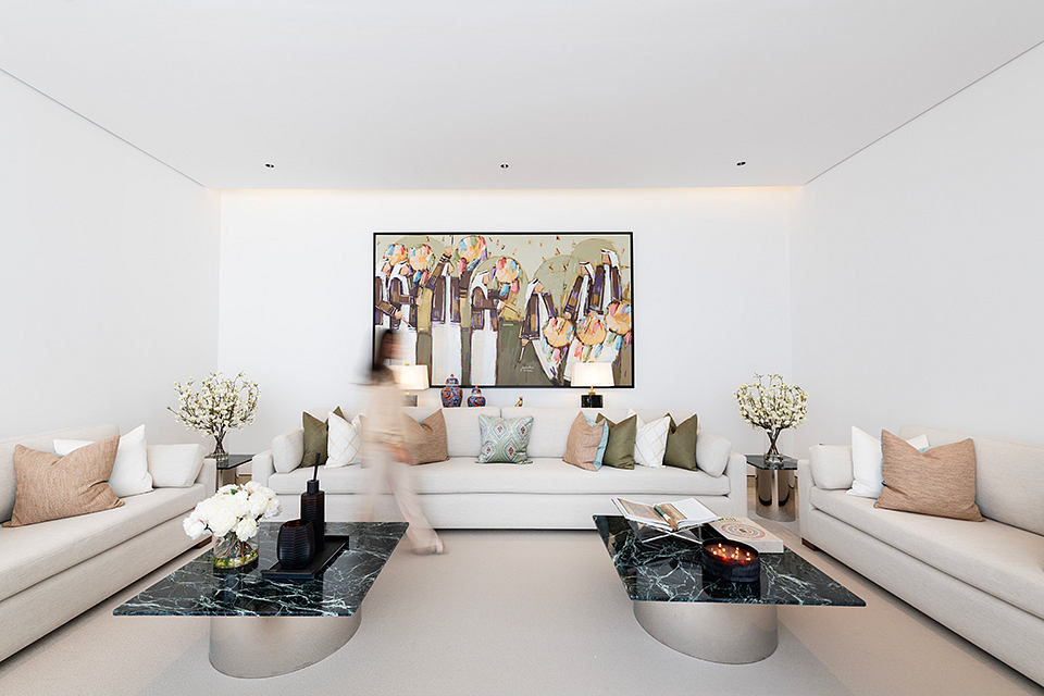 Minimalist living room with modern art, plush sectionals, marble coffee tables.