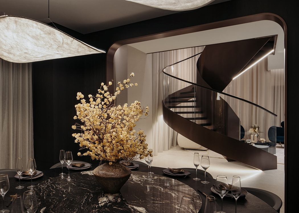 Elegant spiral staircase, marble table, and a striking floral centerpiece in a modern space.