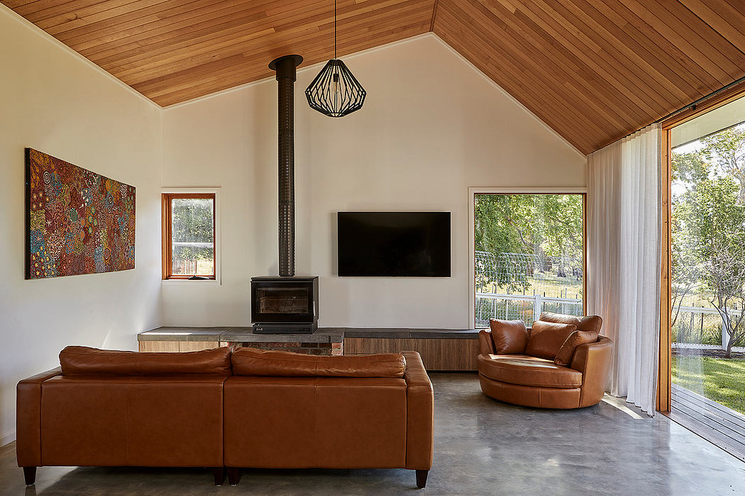 Cozy living room with warm wood paneling, leather furniture, and a modern fireplace.