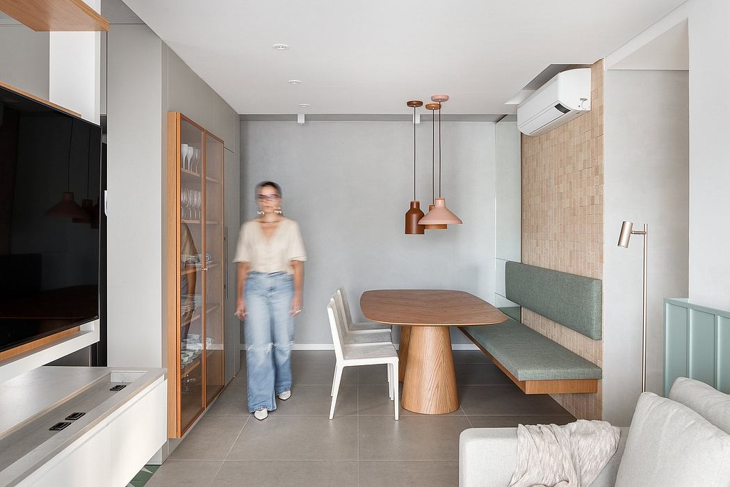 Sleek modern dining area with wood and gray tones, built-in bench, and pendant lights.