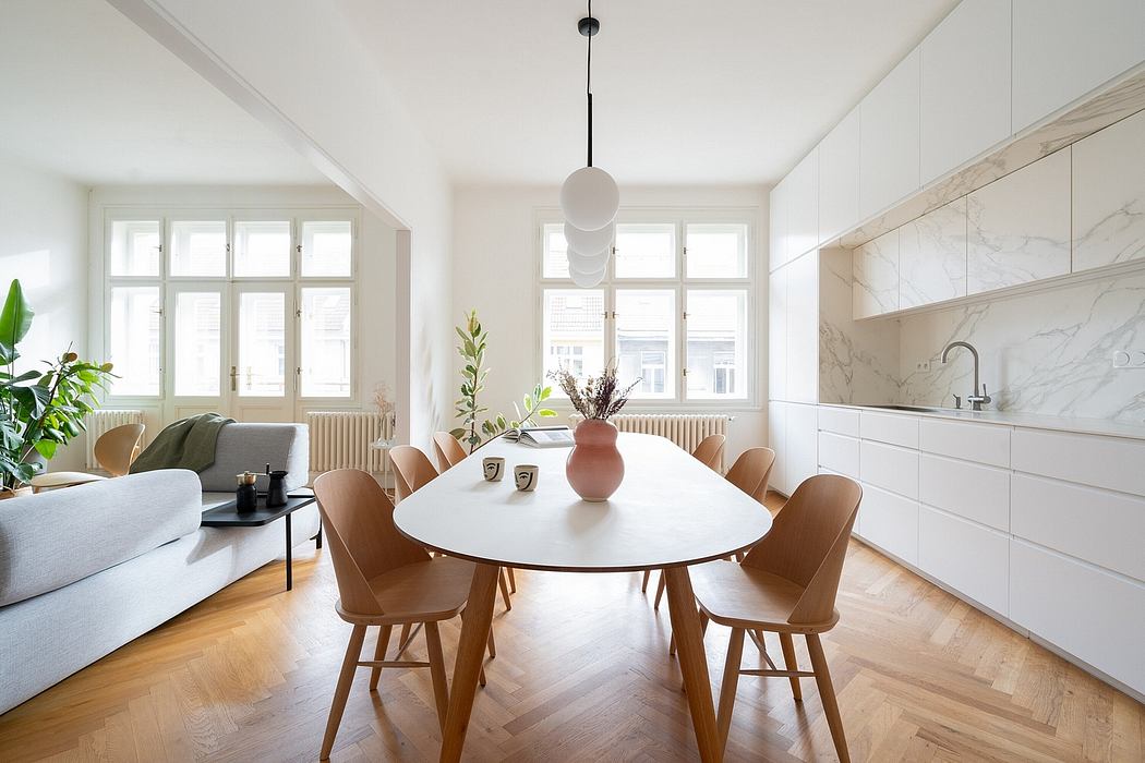 Bright, minimalist dining room with large windows, modern furniture, and a marble backsplash.