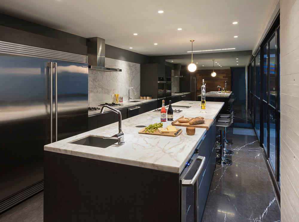 Sleek, modern kitchen with marble countertops, stainless steel appliances, and recessed lighting.