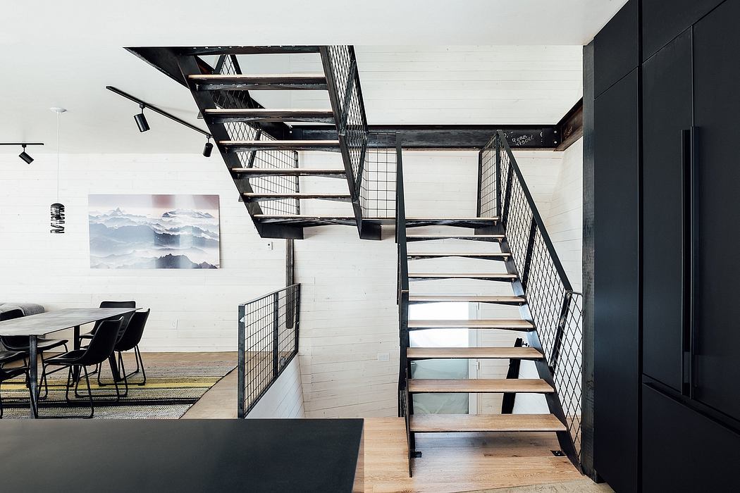 A modern, open-concept loft with a striking metal staircase and minimalist decor.