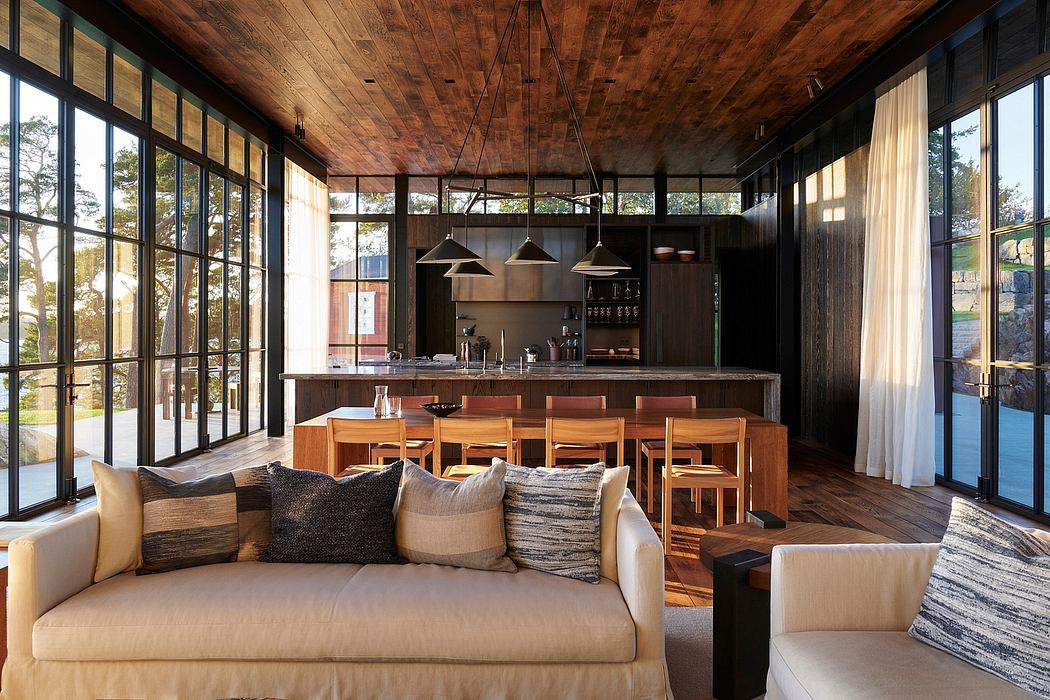 Rustic cabin-inspired interior with glass walls, wooden beams, and a modern kitchen.