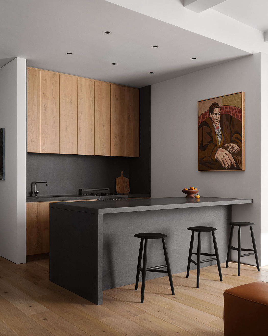 Modern kitchen with wooden cabinetry, black countertop, and statement artwork.