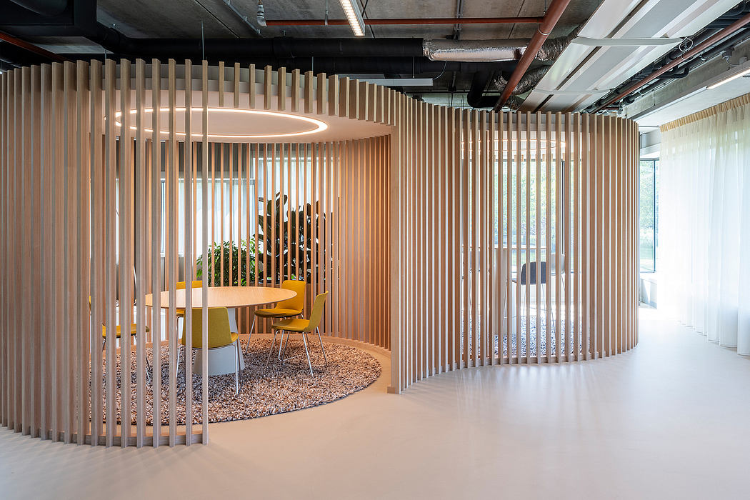 Wooden slat partition walls define a cozy seating area with circular rug and yellow chairs.
