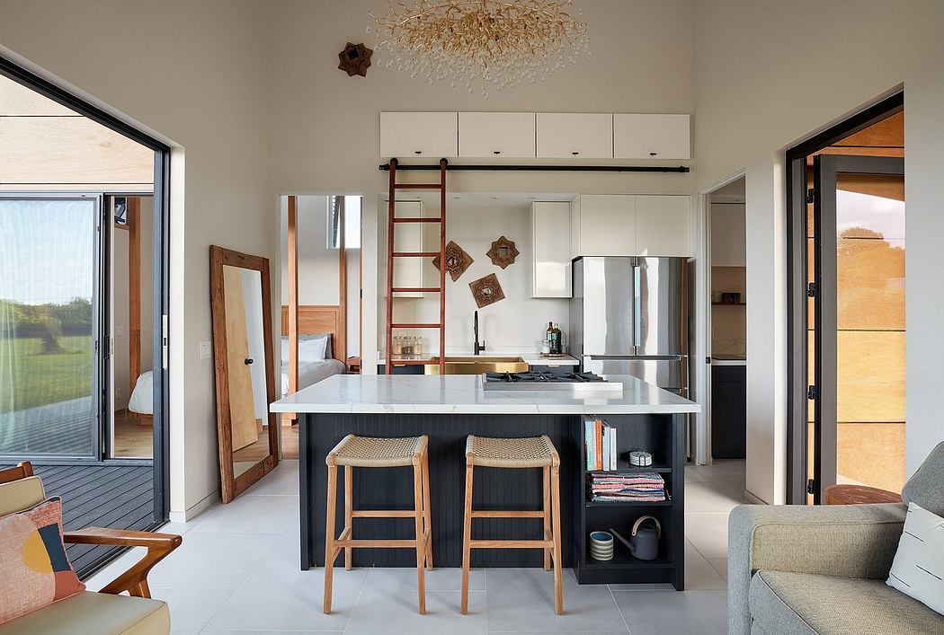 Spacious, modern kitchen with black island, wooden decor, and a stunning chandelier.