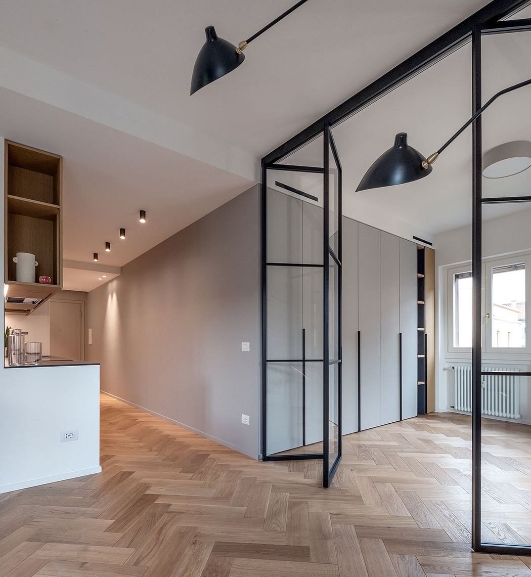 Sleek, modern interior with industrial-style lighting, glass-paneled walls, and herringbone wood floors.