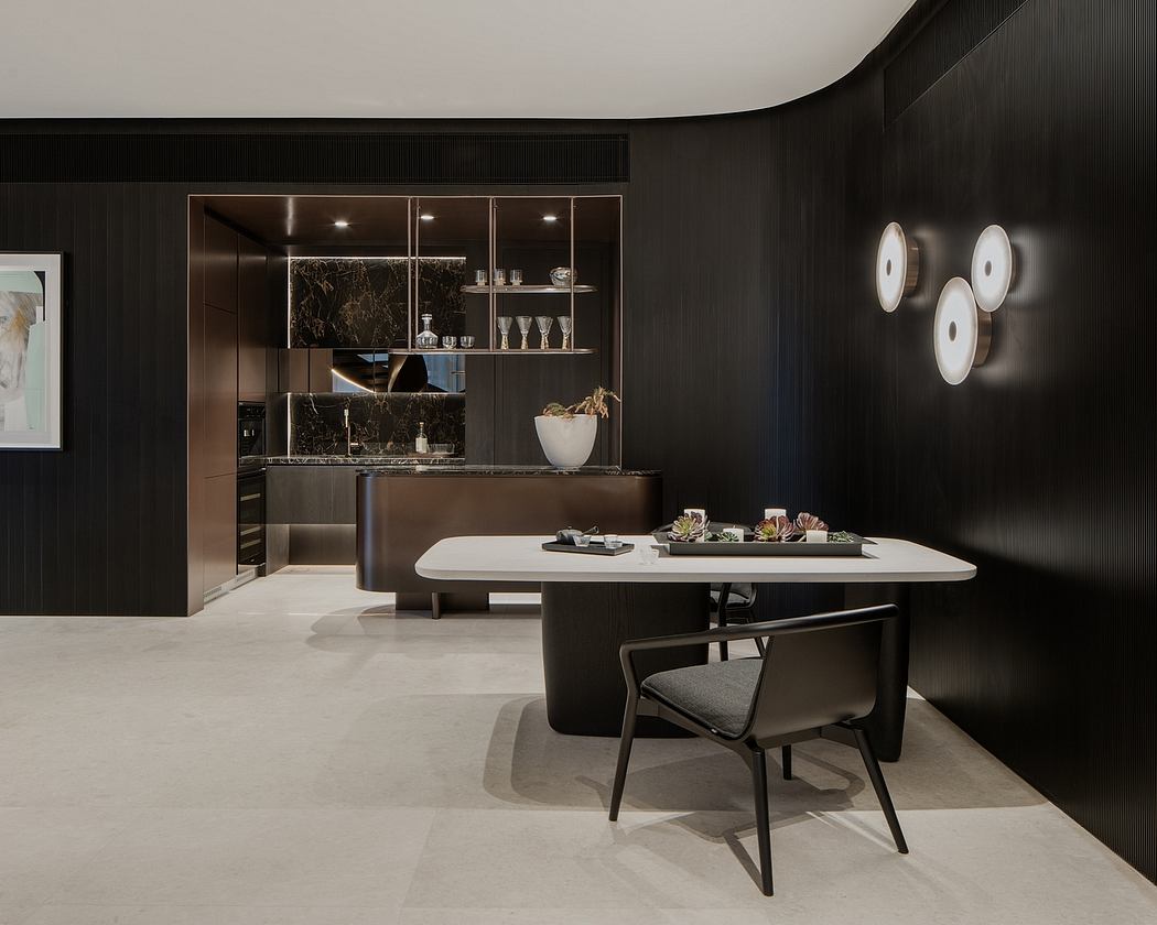 Sleek, modern kitchen with dark cabinetry, minimalist dining table, and stylish wall sconces.