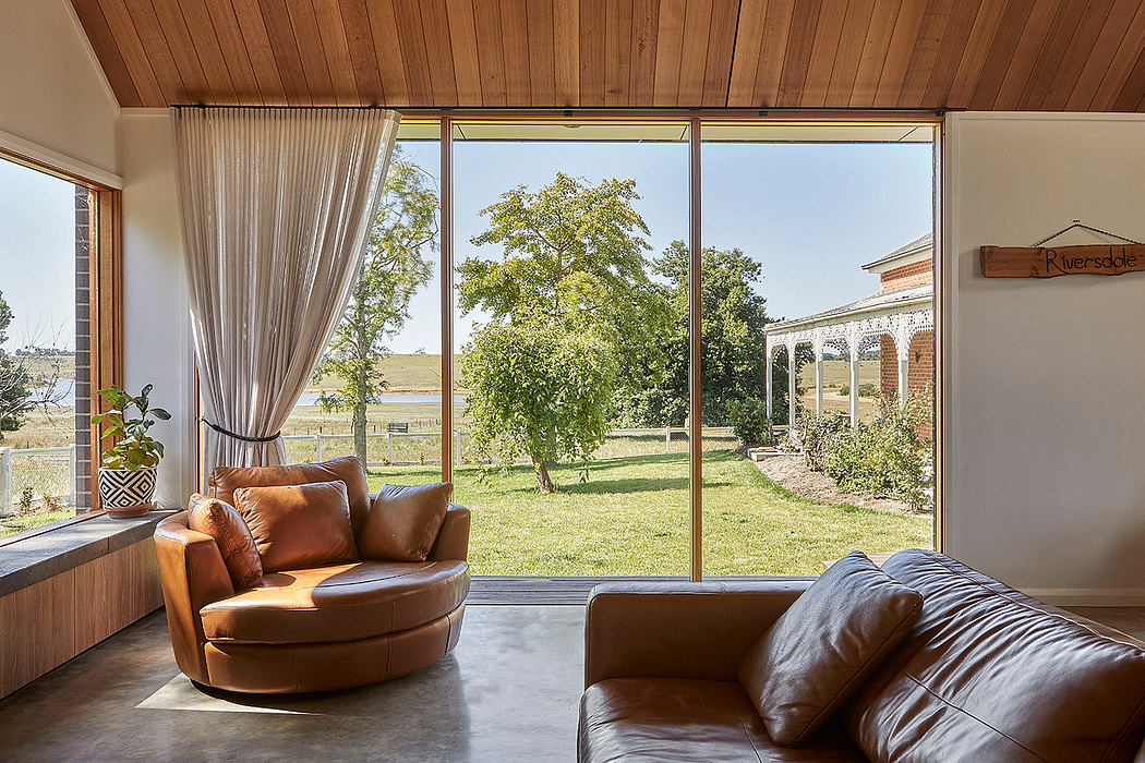 Warm wood-paneled interior with large windows overlooking lush greenery outside.